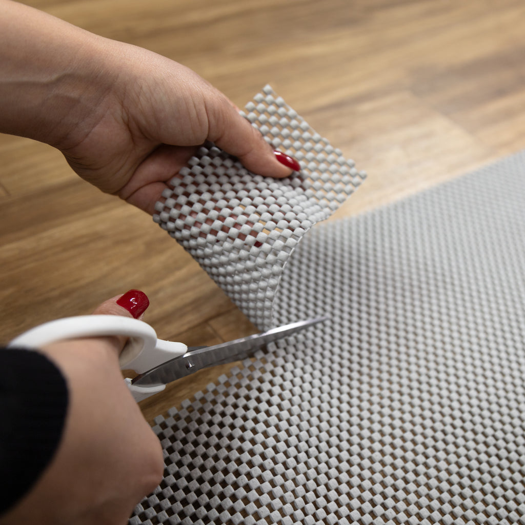 Non-slip rug pad, textured for grip on various floors, slim and neutral-colored for discreet use under rugs.